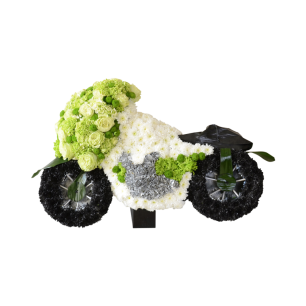 En blomsterarrangemang format som en motorcykel, med vita, gröna och svarta blommor som skapar hjul och kaross.