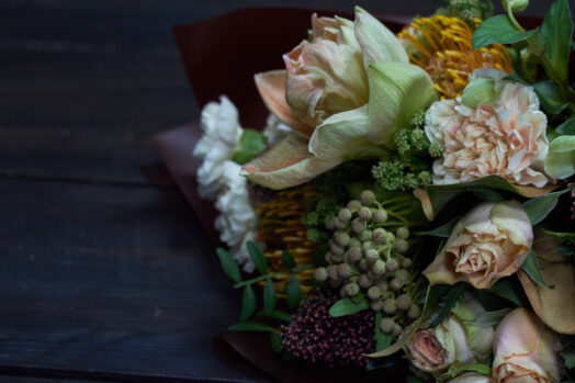 Bukett med olika blommor i dämpad belysning.